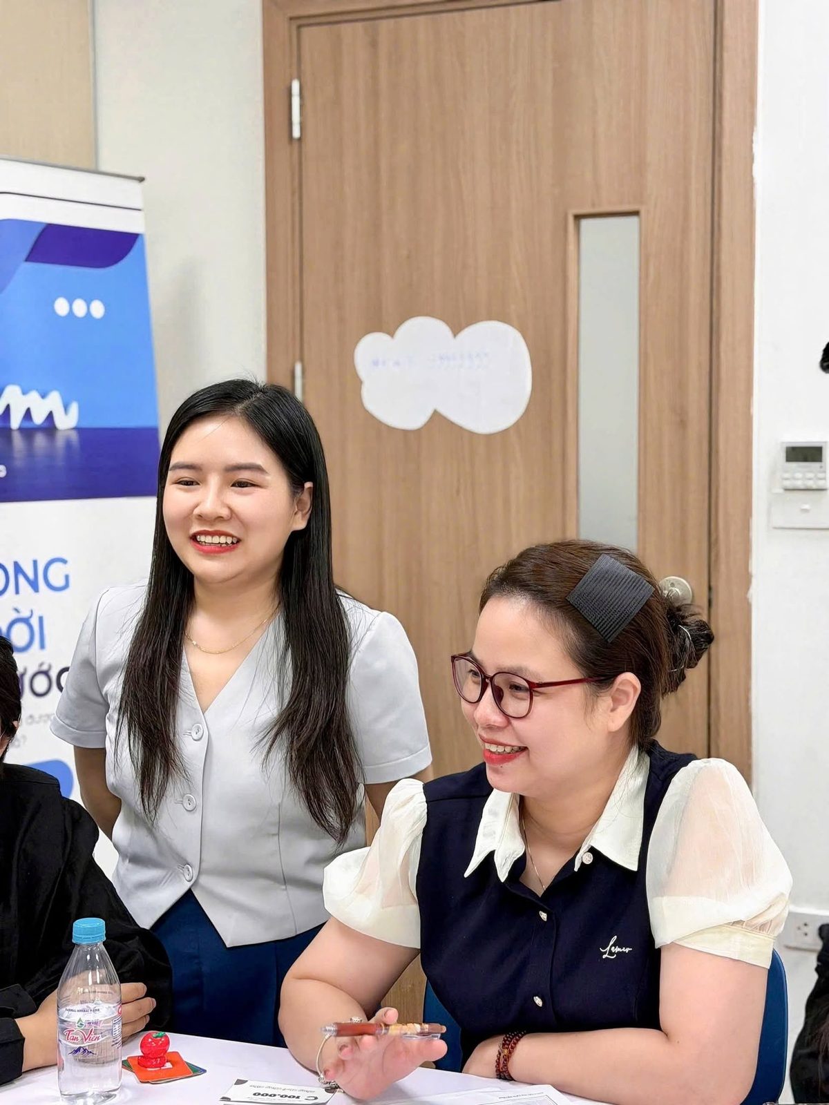 Hai người chơi tươi cười bên banner LiFin