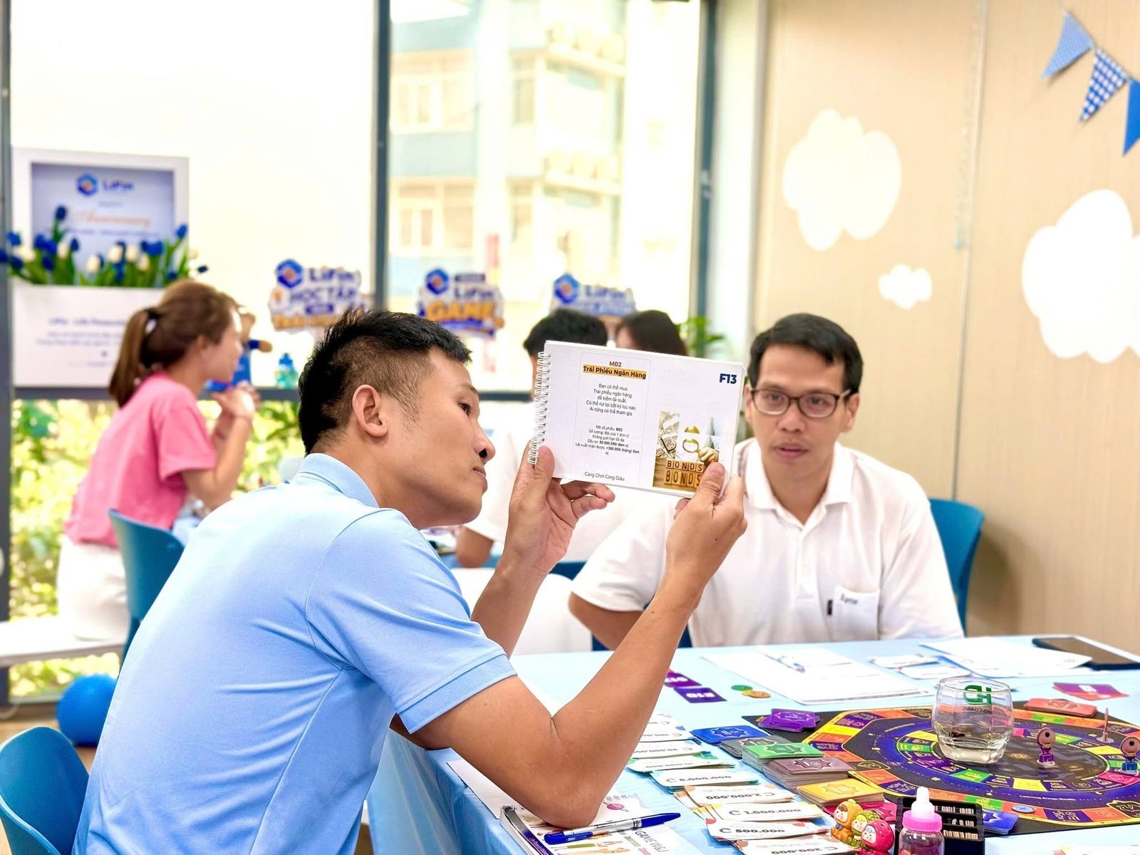 Facilitator giải thích thẻ bài cho người chơi tại bàn LiFin Game